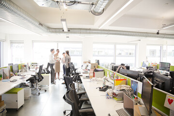 Business people talking in open plan office