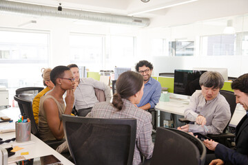 Business people meeting at computer in open plan office