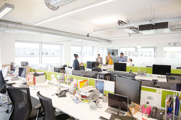 Business people talking in open plan office