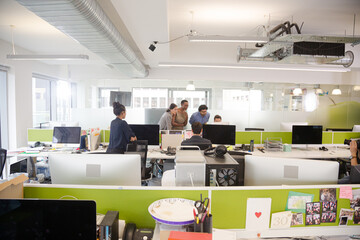 Business people talking in open plan office