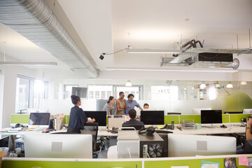 Business people talking in open plan office