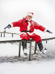Cheerful Santa Claus in red traditional costume go to fly.