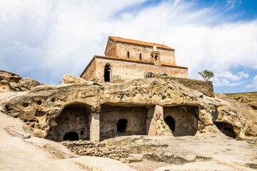 Fototapeta premium Ancient church monastery in caves city build in rocks in Uplistsikhe Georgia