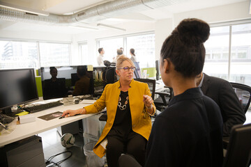 Business people talking in open plan office