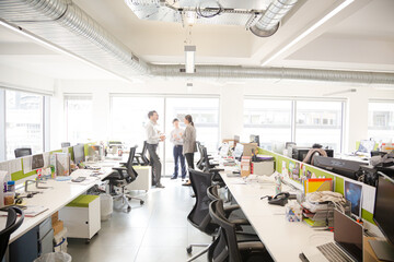 Business people talking in open plan office