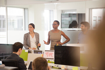 Business people talking in open plan office