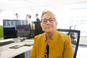 Portrait of confident businesswoman in open plan office