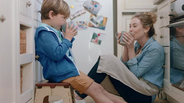 mother and son drinking hot chocolate together in kitchen happy mom caring for little boy enjoying homemade delicious beverage at home