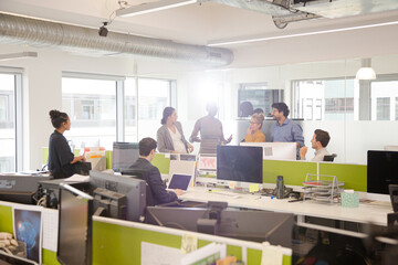 Business people talking in open plan office