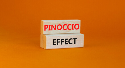 Pinoccio effect symbol. Concept words Pinoccio effect on wooden blocks on a beautiful orange background. Business and Pinoccio effect concept, copy space.