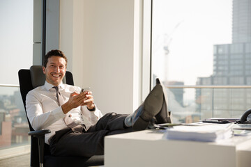 Businessman relaxing at desk in modern office