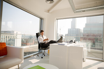 Businessman relaxing at desk in modern office