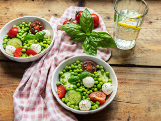 Salad vegetarian. Fresh vegetable salad with tomato, cucumber, basil, green peas, mozzarella cheese.