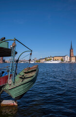 Fototapeta premium Boats at the bay Riddarfjärden and the island Kungsholmen with the Town City Hall and the pier Norr Mälarstrand a sunny day, seen from the pier Söder Mälarstrand