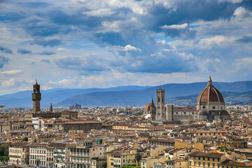 Beautiful panoramic view of Florence in a sunny day with blue sky and clouds. Italian panorama of a city in Tuscany. Top aerial landscape view of an ancient historical tourist destination in Europe.