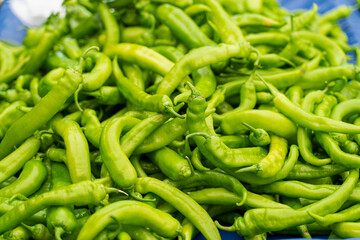 Mix of green chili peppers, capi color assortment on vegetable market.