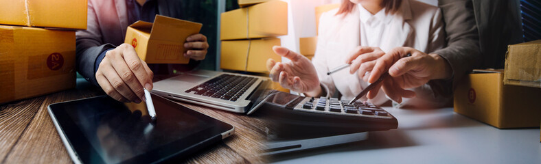 Young woman small business owner online shopping at home. taking note of orders from customers with mobile phones. SME entrepreneur or freelance life style concept.