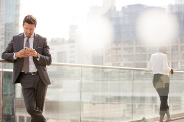 Businessman using smartphone on balcony