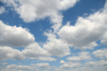 Naklejka na ściany i meble Bright blue sky with fluffy white clouds