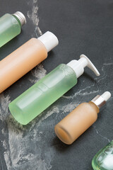 Natural cosmetic products on a black marble background. Mockup of cosmetic bottles.