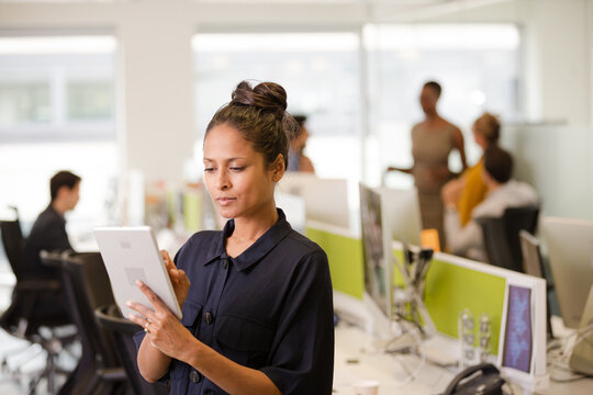 Businesswoman using tablet computer in open plan office