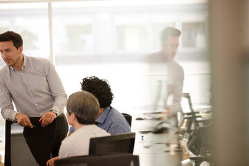 Businessmen talking in open plan office