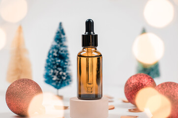 Essential oil or serum in a cosmetic bottle on a round podium with Christmas decor. Cosmetics, skin care in winter. Flavored oil bottle on white podium
