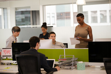 Business people talking in open plan office