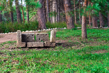 A bench of concrete blocks of different sizes stands on the ground