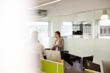 Business people talking in open plan office