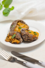 Stuffed Parasol Mushroom with cheese and herbs on white plate. Vertical format