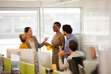 Business people talking in open plan office