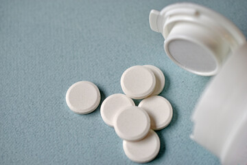 White flat medicine tablets on a blue background