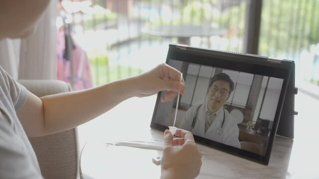 Close up scene from behind of people have online consultation with doctor to self test antigen test kit from home. Medical Consult online service concept for SARS 2019-nCoV COVID-19 coronavirus.