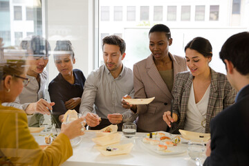 Business people enjoying sushi lunch in conference room