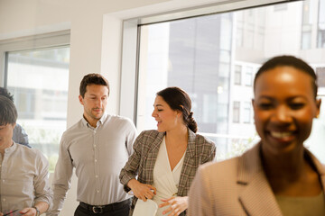Smiling business people leaving conference room