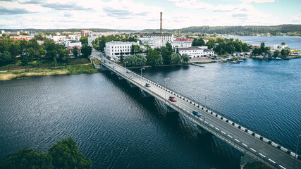 a long concrete bridge across the river along which cars travel, a city, low concrete houses in the...
