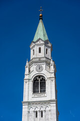 Fototapeta na wymiar Bell Tower of the Catholic Parish Church in Cortina d' Ampezzo, Dolomites, in the Belluno region of Italy