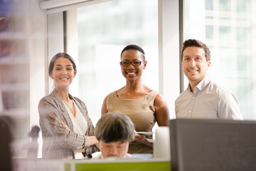 Smiling business people posing in open plan office