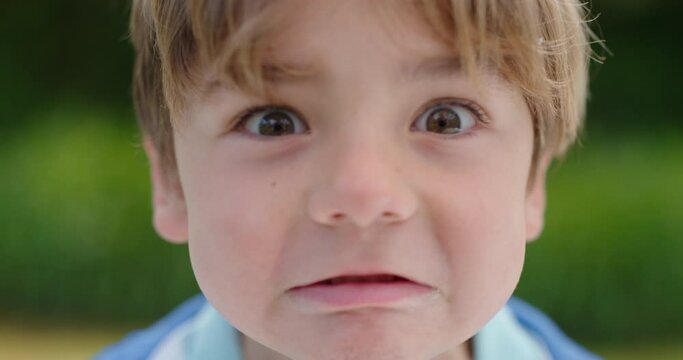 portrait cute little boy making faces having fun happy kid enjoying making silly expressions in sunny park 4k