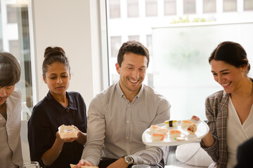 Business people enjoying sushi lunch in conference room