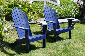 pair of  dark blue adirondack chairs on the front lawn