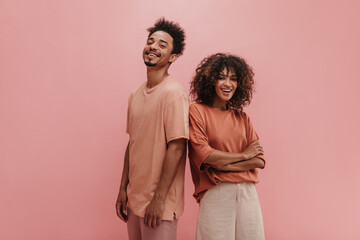 photo below belt of cheerful people of exotic appearance on isolated nacre pink wall. brunette with...