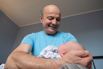 Grandfather holding a beautiful newborn baby girl