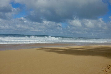 Fototapeta na wymiar empty tropical beach with waves rolling onto the sand