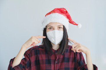 Close up portrait of woman in medical, disposable mask and Christmas red cap