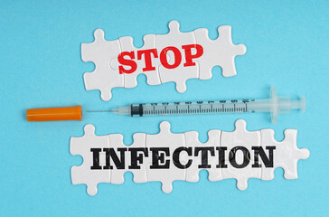 On a blue background, a syringe and puzzles with the inscription - STOP INFECTION
