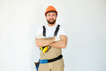 Portrait of confident caucasian mechanic with beard in overall, shirt having arms crossed, looking...