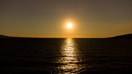 Naklejka premium Bright sunset with large yellow sun under the sea surface