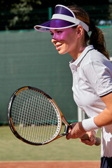 Female tennis player playing game on outdoor court. Athlete caucasian woman with racket during match. Sports in competition. Adorable athlete lady in uniform enjoy game, training at summer day